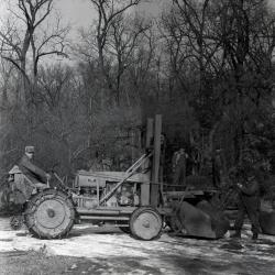 Clarence Godshalk driving Arboretum's first international tractor with front end loader carrying tree