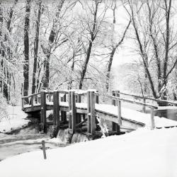 Wooden bridge covered in snow over DuPage River dam