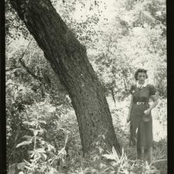 Maude Kammerer standing in wooded area next to tree