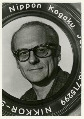 John Kohout headshot framed in camera lens