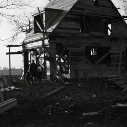 Clarence Godshalk's first Arboretum house under construction, front view with John and girls next to house

