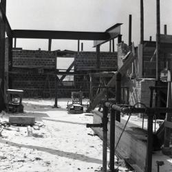 Administration Building construction, view from inside construction site showing window opening and one crossbeam in winter