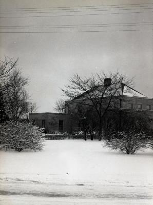 Administration Building, side view in winter partially obstructed by bare trees