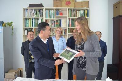 Nicole Cavender and Murphy Westwood presenting a photograph to colleagues at the Chenshan Shanghai Botanical Garden in China