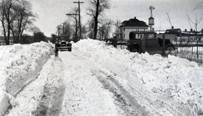 Clarence Godshalk's Model A Ford Roadster in distance on snow covered road, South Farm in background
