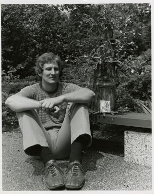 John Slavic seated on ground with oak puppet