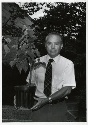 George Ware outdoors holding plant
