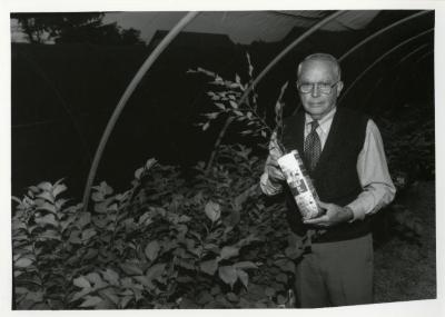 George Ware holding plant in quonset hut