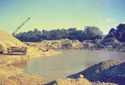 Arbor Lake excavation, man operating equipment to the left of partially filled lake