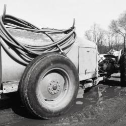 Tractor pulling water wagon with hose