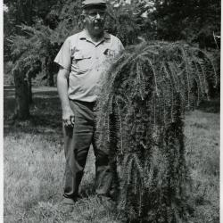 Roy Nordine outdoors standing next to plant