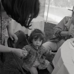 Arbor Day activities at The Morton Arboretum, girl holding woman's hand at Face Painting station