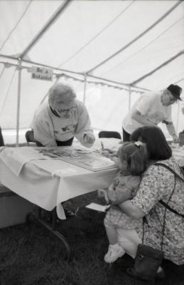 Arbor Day activities at The Morton Arboretum, girl and woman creating Herbarium specimen at Be a Botanist station