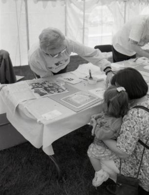 Arbor Day activities at The Morton Arboretum, woman assisting girl and woman create Herbarium specimen at Be a Botanist station