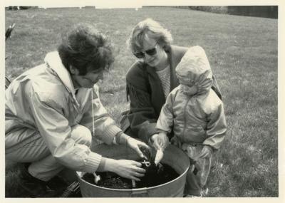 Arbor Day, Susan Klatt and two visitors tree planting in barrel
